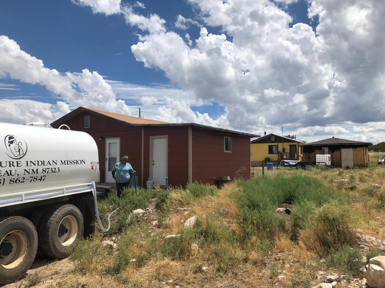Water truck delivers water to house.